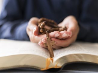 Mão com rosário e bíblia para consagração