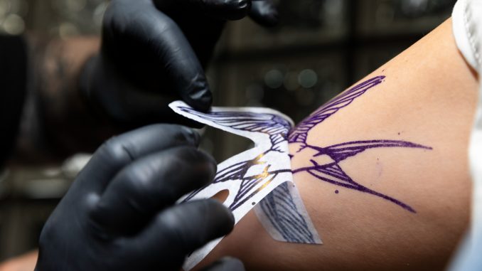experienced-tattoo-artist-working-client-tattoo tatuagem